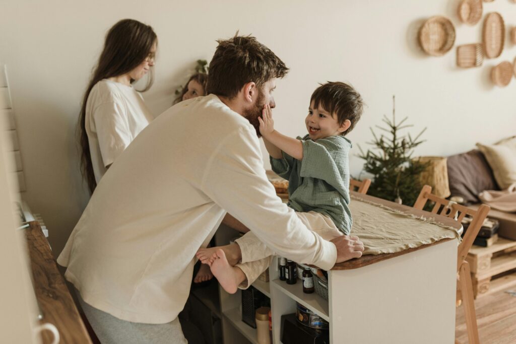 A father and son share a loving moment indoors, capturing family warmth.