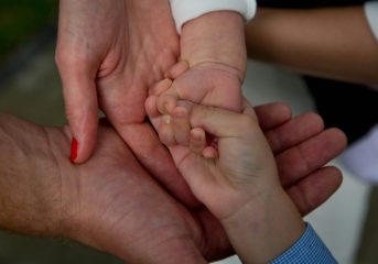 Close-up of a family joining hands, symbolizing love and connection.