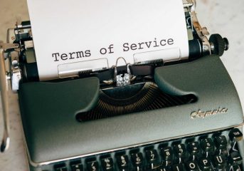 Close-up of a vintage typewriter printing 'Terms of Service' on paper, ideal for legal and business themes.